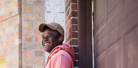A young man in a hoodie looking at his phone.