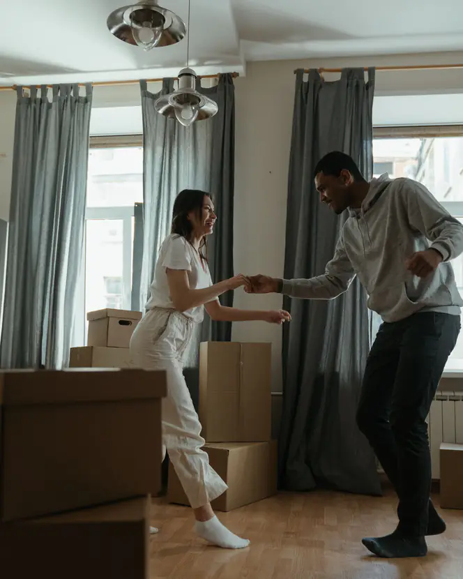 A couple dancing among cardboard boxes in their new home.