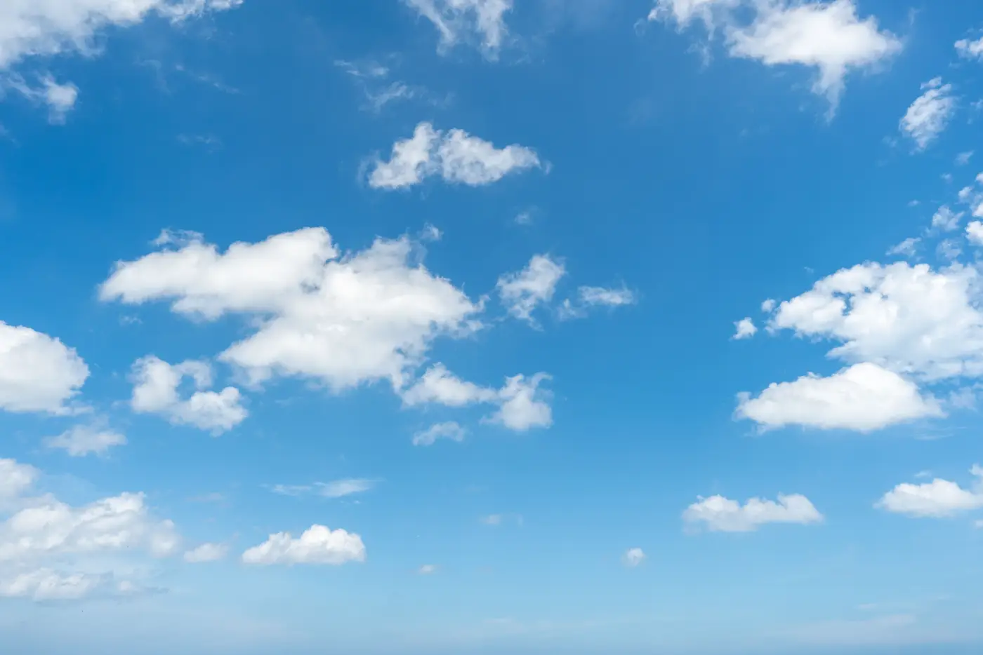 Bright blue sky with soft white clouds.