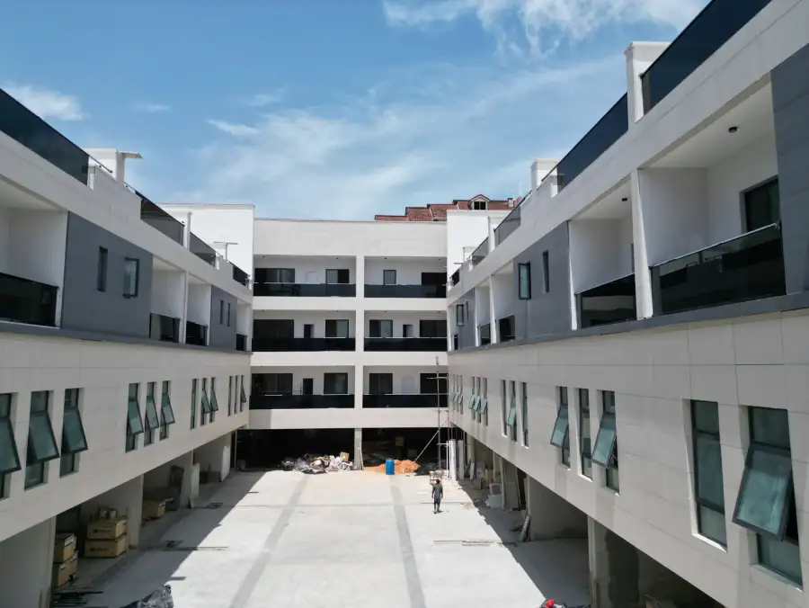 A modern apartment complex under construction against a clear sky.